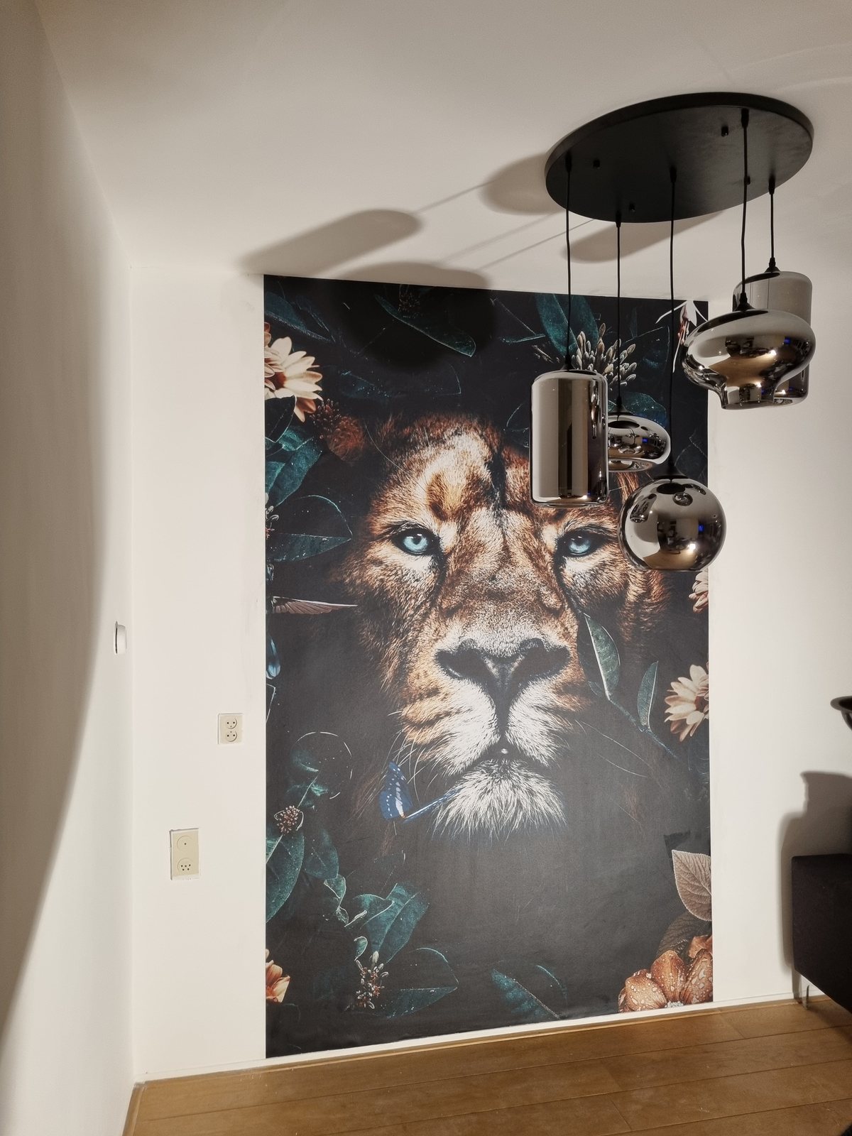 Woonkamer met een fotobehang van een leeuw en een zwarte hanglamp